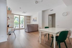 un soggiorno con tavolo e sedie bianchi di Easylife - Modern and Spacious apt in Fiera City Life a Milano
