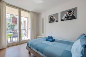 a bedroom with a blue bed and a balcony at Easylife - Modern and Spacious apt in Fiera City Life in Milan