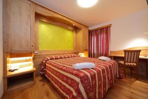 a hotel room with a bed and a desk at Hotel Al Sole in Tarvisio