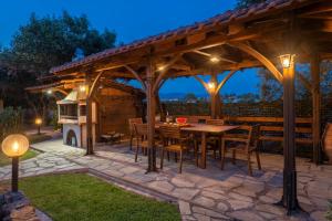 a patio with a wooden pergola and a table and chairs at Windmill Villa in Kalyves Poligirou
