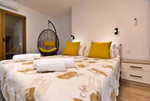 een slaapkamer met een groot bed met gele kussens bij Apartments Kiwi Rovinj in Rovinj