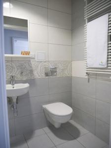 a white bathroom with a toilet and a sink at CKS Kraków (Centrum Konferencyjno-Szkoleniowe CS Natura Tour) in Kraków