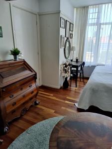 een slaapkamer met een bed, een dressoir en een bureau bij Cosy appartement Wassenaar in Wassenaar