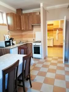 a kitchen with a table and chairs in a room at Apollo Vendégház in Edelény