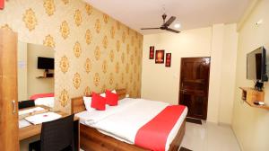 a hotel room with a bed and a desk with a computer at Hotel Neelkanth in Jabalpur