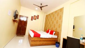 a bedroom with a bed with red and white pillows at Hotel Neelkanth in Jabalpur +27 photos