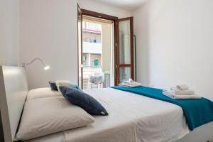 ein weißes Schlafzimmer mit einem großen Bett und einem Fenster in der Unterkunft Tidy House in Alghero