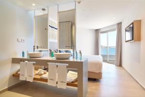 a bathroom with two sinks and a large mirror at Can Salia in San Antonio Bay