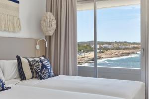 a bedroom with a bed and a view of the ocean at Can Salia in San Antonio Bay