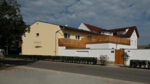 ein Haus mit einem Holzbalkon darüber in der Unterkunft Nachtquartier Zur Dankbarkeit in Podersdorf am See