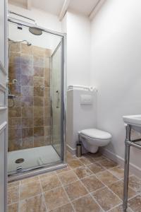 a bathroom with a shower and a toilet at Hôtel Le Relais de Poste Arles Centre Historique in Arles