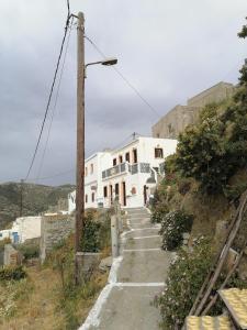 a white building on a hill with a street light at Kalliopis Studio in Olympos