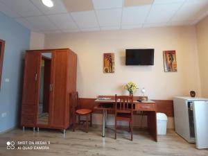 a room with a desk and a table with chairs at Joker Apartman in Sárvár