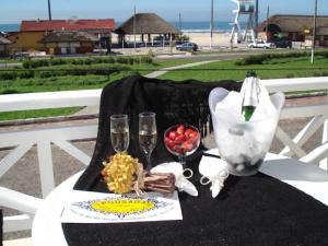 a table with wine glasses and a plate of food at Pousada Solar Dom Kido in Torres