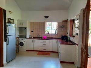 a kitchen with white cabinets and a white refrigerator at Tobias Villas in Cavelossim