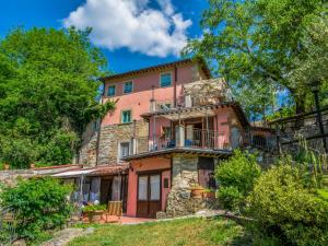 a large pink house on a hill with trees at Apartment Giallo by Interhome in Il Molinaccio
