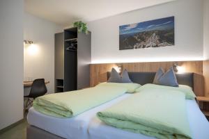 een slaapkamer met 2 bedden en een bureau bij Haus Markus Strolz in Sankt Anton am Arlberg