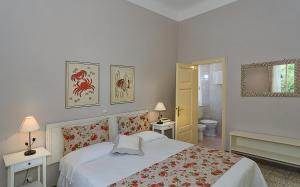 a white bedroom with a bed and a bathroom at Albergo Grande Italia in Marina di Pietrasanta