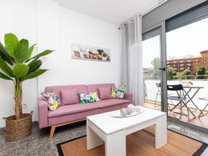 羅列特海岸的住宿－Apartment Marina by Interhome，客厅配有粉红色的沙发和桌子