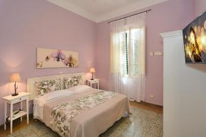 een slaapkamer met een bed, 2 tafels en een raam bij Albergo Grande Italia in Marina di Pietrasanta