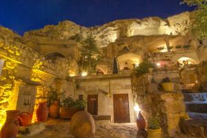 a stone building with vases in front of a mountain at 4 Oda Cave House - Special Class in Urgup