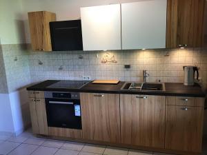 a kitchen with a sink and a stove and cabinets at Ferienwohnung Panoramablick in Rimbach