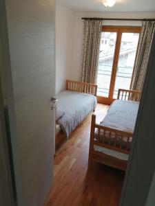 a bedroom with two beds and a window at Cervinia in Breuil-Cervinia