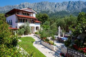 a house with a garden and mountains in the background at Casa Viter Zaostrog in Zaostrog