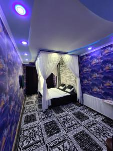 1 dormitorio con 1 cama en una habitación con luces moradas en Элитная Квартира, en Bukhara
