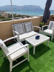 een groep stoelen en een tafel op een balkon bij Sealoft in Isola delle Femmine