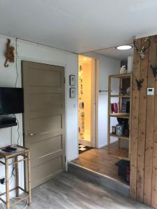 a room with a closet and a door and a television at Beemster Tiny House in Zuidoostbeemster