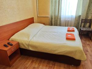a bedroom with a bed with two red boxes on it at Гостевой дом Ася in Anapa