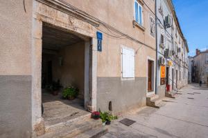 eine leere Gasse mit Blumen in einem Gebäude in der Unterkunft Soba Cres in Cres