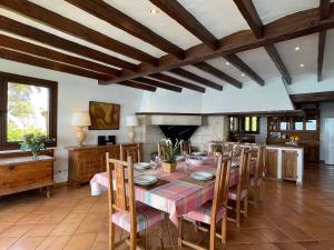 una sala da pranzo con tavolo, sedie e camino di Villa Kamok a Molinar de Levante