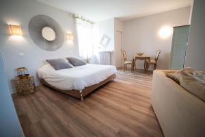 1 dormitorio con cama, mesa y sofá en BOUTIK Hotel O'Domaine, en Chis