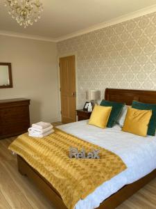 een slaapkamer met een groot bed met gele en groene kussens bij Broadhaven Bay View Private House in Belmullet