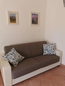 a couch sitting in a living room with two pillows at Casa del Porto in Scario