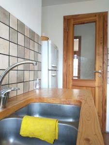 uma cozinha com um lavatório e uma toalha amarela em MM em San Carlos de Bariloche