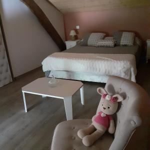 un animal de peluche sentado en una silla en un dormitorio en location chambre d hotes clodeguy No 1 en Saint-Sylvestre-sur-Lot