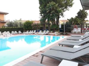 a swimming pool with lounge chairs in a hotel at Hotel da Roberto in Lazise