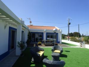 a house with a yard with chairs in the grass at Moradia Faria in Fataca