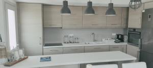 a kitchen with white cabinets and a white counter top at Akrotiri Skyros in Skiros