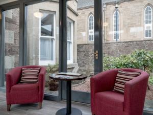 two chairs and a table in front of a window at Kirkstyle Hotel in Biggar