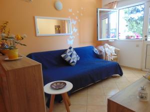 een woonkamer met een blauwe bank en een tafel bij Apartments Elelu in Dubrovnik