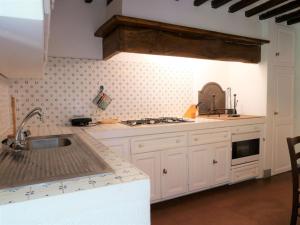 a kitchen with white cabinets and a sink at Apartment La Torre by Interhome in Podere Caminino