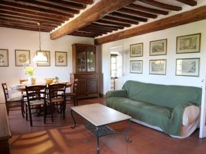 een woonkamer met een groene bank en een tafel bij Apartment La Torre by Interhome in Podere Caminino
