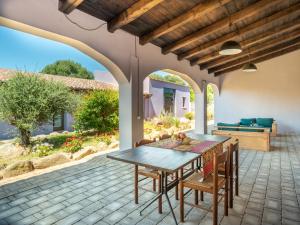 - patio z drewnianym stołem i krzesłami w obiekcie Holiday Home Oliviola by Interhome w mieście Santa Maria