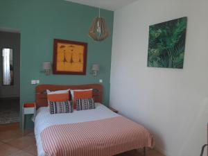a bedroom with a bed with a striped bedspread at hôtel la tour des fées in Quissac +21 photos