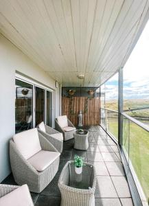a screened in porch with chairs and tables at Luxury Sea View Apartment in Portrush