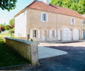 une ancienne maison en briques avec une clôture en pierre devant elle dans l'établissement Château du Mesnil Soleil , gites et chambres d'hôtes, à Damblainville